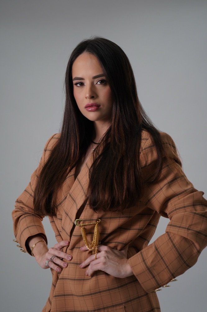 Dra. Hellenna Dutra em ambiente profissional, blazer xadrez