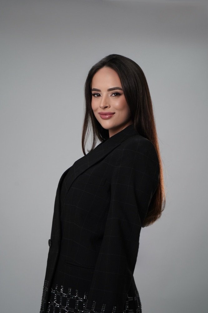 Dra. Hellenna Dutra sorrindo, blazer preto